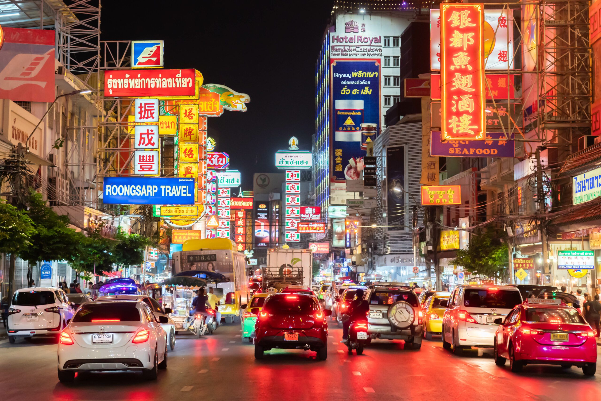 Bangkok streets at night with neon signs.