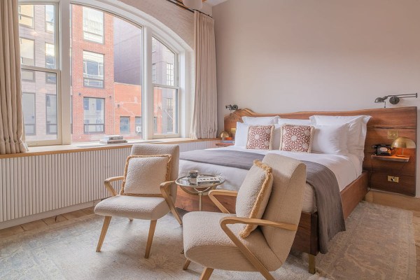 A bed and chairs in a hotel room