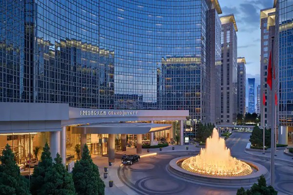 exterior of a hotel with an illuminated fountain