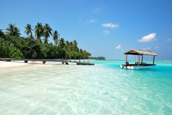 clear and blue water near the shore with a boat to the right