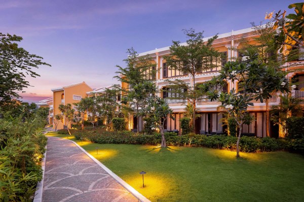 exterior of a 3-story hotel surrounded by greenery