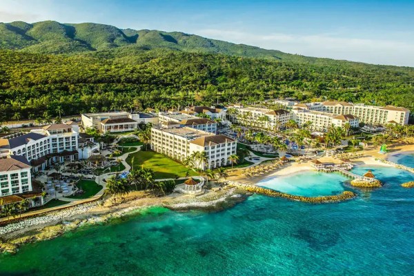 Aerial view of a large resort next to clear blue waters