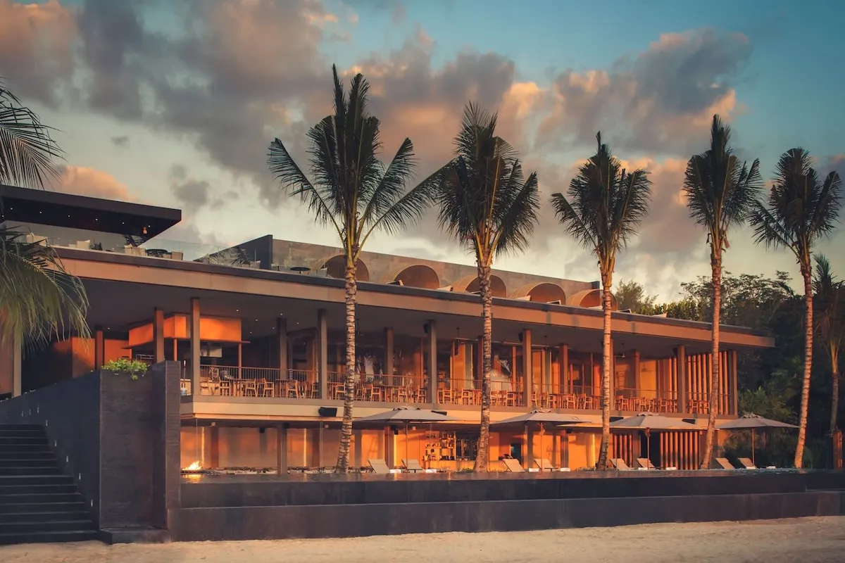 exterior of a beachside hotel reflecting a sunset