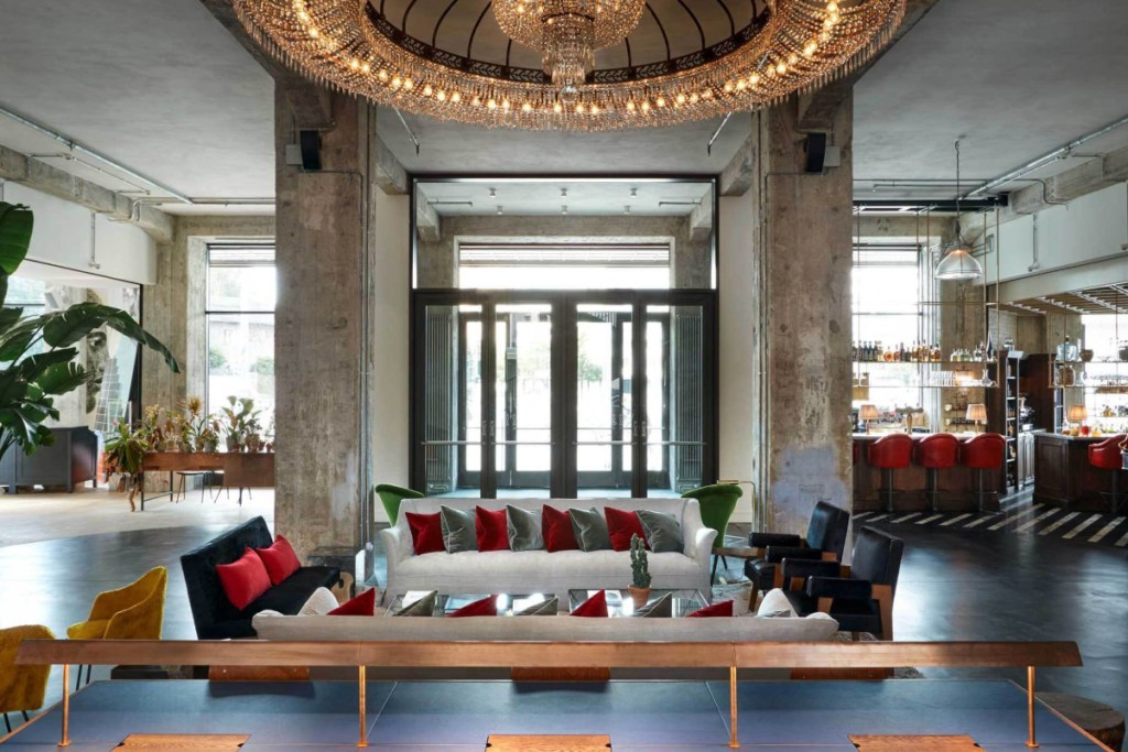 image of the interior of a member's club run by Soho House, with lots of fancy couches and big windows and high ceilings