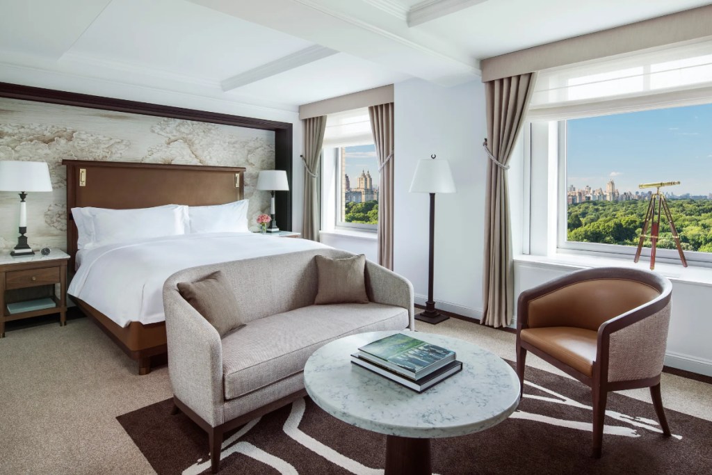 Image of a brightly lit luxury hotel room overlooking Central Park.