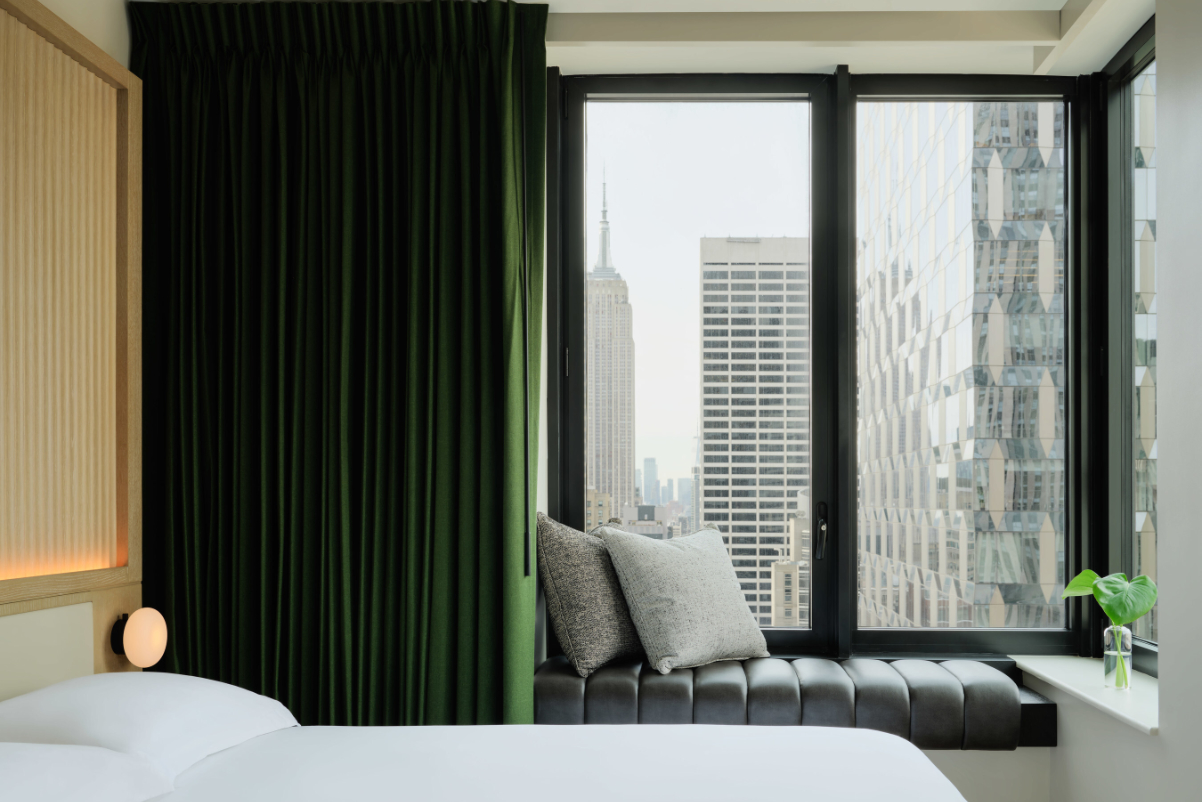 Image of a brand new guest room in Midtown, Manhattan with a view out the window of an upper upscale hotel during the daylight