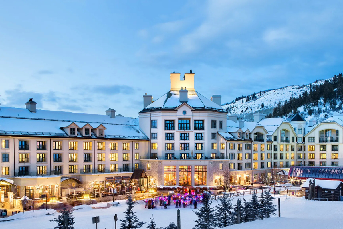 exterior of a luxury resort in Colorado with snowfall at sunset