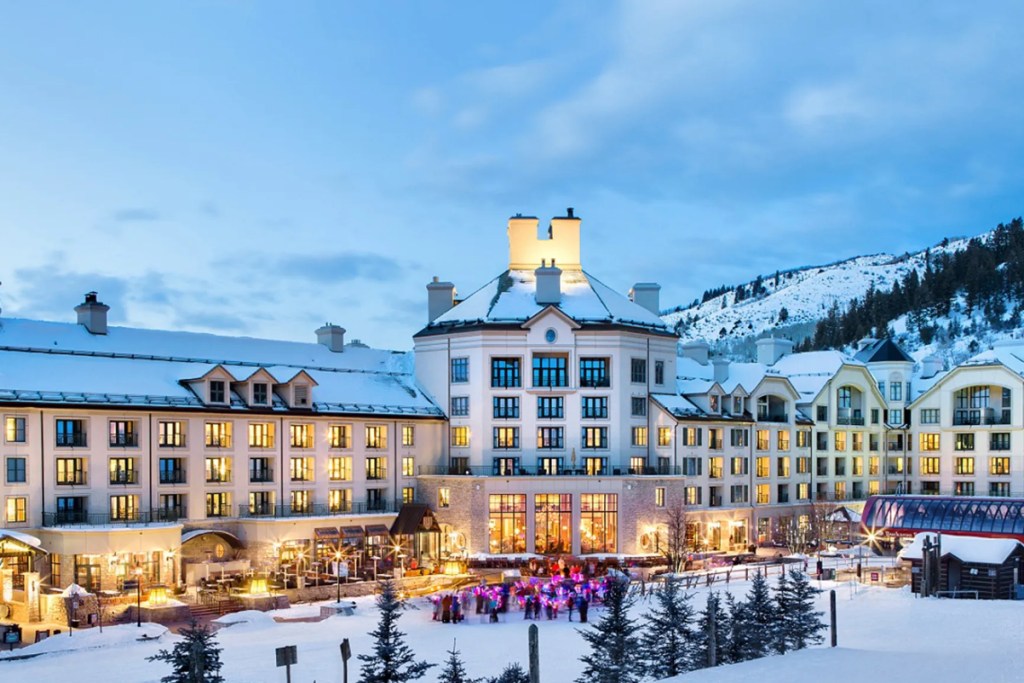 exterior of a luxury resort in Colorado with snowfall at sunset